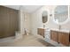 Modern bathroom with double vanity, lighted mirrors, and tiled walk-in shower at 17 Winding Rd, Henderson, NV 89052