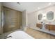 This contemporary bathroom features a soaking tub, glass shower, and floating double vanity with illuminated mirrors at 17 Winding Rd, Henderson, NV 89052