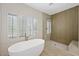 Bright bathroom with a soaking tub, walk-in shower, and shuttered windows at 17 Winding Rd, Henderson, NV 89052