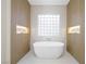 Luxurious bathroom features a soaking tub with modern fixtures and natural light from the glass block window at 17 Winding Rd, Henderson, NV 89052