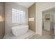 Bright bathroom featuring a soaking tub and a view into the adjacent walk-in closet at 17 Winding Rd, Henderson, NV 89052