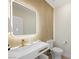 Modern powder room featuring an illuminated mirror, gold fixtures, and wood slat accent wall at 17 Winding Rd, Henderson, NV 89052