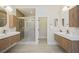 Bright bathroom featuring a glass shower, dual floating vanities, and modern light fixtures at 17 Winding Rd, Henderson, NV 89052
