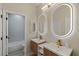 Well-lit bathroom featuring double sink with backlit mirrors, and a shower-tub combo at 17 Winding Rd, Henderson, NV 89052
