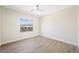 A bright bedroom with wood-look flooring, a ceiling fan, and a large window with mountain views at 17 Winding Rd, Henderson, NV 89052