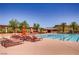 Large community pool with lounge chairs and umbrellas on a sunny day at 17 Winding Rd, Henderson, NV 89052