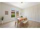 Bright dining room featuring modern light fixture, panel accent wall, and views of neighborhood landscaping at 17 Winding Rd, Henderson, NV 89052
