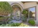 Welcoming front entryway showcasing modern glass door, manicured landscaping and decorative foliage at 17 Winding Rd, Henderson, NV 89052