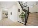 Bright entryway with stairs featuring black railing, wood steps, and light wood flooring at 17 Winding Rd, Henderson, NV 89052