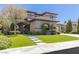 Stunning two-story home features a lush green lawn, manicured landscaping, and a modern architectural design at 17 Winding Rd, Henderson, NV 89052