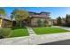 Charming home exterior with manicured lawn, mature trees, and a welcoming entrance, creating great curb appeal at 17 Winding Rd, Henderson, NV 89052