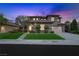 Elegant home exterior at night with lush landscaping, mature trees, and a welcoming driveway at 17 Winding Rd, Henderson, NV 89052
