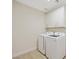 The compact laundry room has a stackable washer and dryer and white cabinets for storage at 17 Winding Rd, Henderson, NV 89052