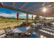 Covered patio features tables and chairs and golf course views at 17 Winding Rd, Henderson, NV 89052