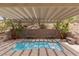 Private backyard pool under a pergola, complemented by stone benches and mature palm trees at 17 Winding Rd, Henderson, NV 89052