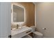 Modern powder room featuring a unique sink, lighted mirror, and decorative wall texture at 17 Winding Rd, Henderson, NV 89052