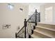 Elegant staircase with dark wood railing and balusters, complemented by light-colored wood steps and decorative lighting at 17 Winding Rd, Henderson, NV 89052