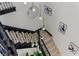 View of the staircase with a decorative chandelier and black metal railing at 17 Winding Rd, Henderson, NV 89052