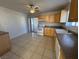 Bright kitchen featuring wood cabinets, white appliances, and tile floor at 132 W Victory Rd, Henderson, NV 89015