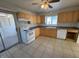 Bright kitchen featuring wood cabinets, white appliances, and tile floor at 132 W Victory Rd, Henderson, NV 89015