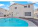 Exterior view of the home featuring a swimming pool and lush trees at 2196 Pescara Ct, Las Vegas, NV 89123