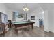 Spacious game room with hardwood floors, a vintage style pool table and an adjacent blue kitchen at 2196 Pescara Ct, Las Vegas, NV 89123