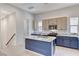 Modern kitchen with blue island, beige cabinets, and granite countertops at 651 Sentinel Spire St, Las Vegas, NV 89138