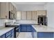 Modern kitchen with blue cabinets, granite countertops, and stainless steel appliances at 651 Sentinel Spire St, Las Vegas, NV 89138