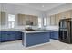 Modern kitchen featuring blue and beige cabinets, granite countertops, and island at 651 Sentinel Spire St, Las Vegas, NV 89138