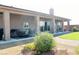 A beautiful covered patio adjacent to a lush landscaped yard and outdoor seating at 1120 W Gray Fox Way, Pahrump, NV 89048