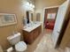 A well-lit bathroom featuring a dark wood vanity, toilet and an open doorway to a bedroom at 1120 W Gray Fox Way, Pahrump, NV 89048