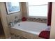 Relaxing bathtub with tiled surround, a window for natural light, and modern fixtures at 1120 W Gray Fox Way, Pahrump, NV 89048
