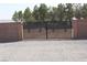 The backyard is secured by a metal gate and brick wall for privacy and security at 1120 W Gray Fox Way, Pahrump, NV 89048