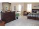Elegant main bedroom with a large dresser, soft carpet, and views of the bathroom at 1120 W Gray Fox Way, Pahrump, NV 89048