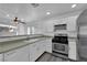 Kitchen with white cabinets, stainless steel appliances, and view of living room at 10596 Corte Sierra St, Las Vegas, NV 89183