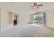 Large main bedroom with carpet, ceiling fan, and access to balcony at 4327 Melrose Abbey Pl, Las Vegas, NV 89141