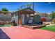 Outdoor view of backyard featuring a small house with a porch, chairs, and a grill at 16 Cerrito St, Blue Diamond, NV 89004