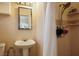 Cozy bathroom featuring a pedestal sink, a mirror, and a shower with a showerhead at 16 Cerrito St, Blue Diamond, NV 89004