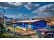 Charming home showcasing a blue exterior, fenced yard and mature landscape under a cloudy sky at 16 Cerrito St, Blue Diamond, NV 89004