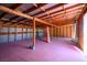 Spacious garage featuring exposed beam ceiling, corrugated metal and wood slat walls, and painted concrete floor at 16 Cerrito St, Blue Diamond, NV 89004