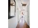 Bright hallway featuring hardwood floors, white walls, and multiple doors at 16 Cerrito St, Blue Diamond, NV 89004