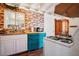 Country kitchen featuring a brick accent wall, wood floors and unique teal cabinetry at 16 Cerrito St, Blue Diamond, NV 89004