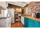 Eclectic kitchen with brick accent wall, stainless steel appliances, and colorful cabinetry at 16 Cerrito St, Blue Diamond, NV 89004
