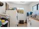 Functional laundry room featuring a washer, a dryer, a window, and ample storage at 16 Cerrito St, Blue Diamond, NV 89004