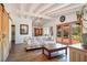 Cozy living room with beamed ceilings, barn door, wood floors and French doors to the yard at 16 Cerrito St, Blue Diamond, NV 89004