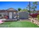 Two sheds, one with a porch and one for storage, on a well-maintained backyard with artifical turf at 16 Cerrito St, Blue Diamond, NV 89004