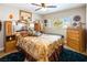 Cozy bedroom with floral bedding, wood furniture, and a ceiling fan at 5413 Lochmor Ave, Las Vegas, NV 89130