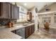 Bright kitchen featuring dark wood cabinetry, granite countertops, and tile backsplash at 5413 Lochmor Ave, Las Vegas, NV 89130