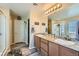 Bathroom featuring double sinks with granite counters and wood cabinets at 6322 Highledge St, North Las Vegas, NV 89081