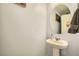 Powder room features a pedestal sink and a round mirror at 6322 Highledge St, North Las Vegas, NV 89081